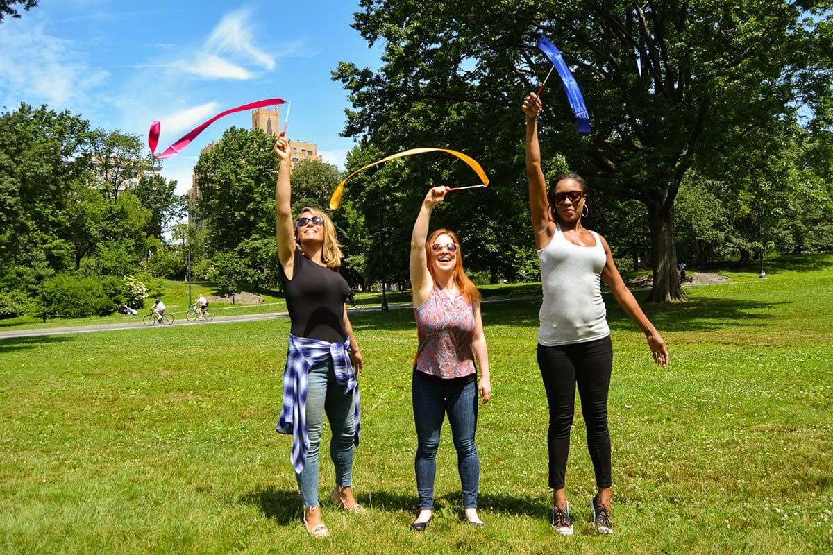 3 Women spinning flags in the middle of a park