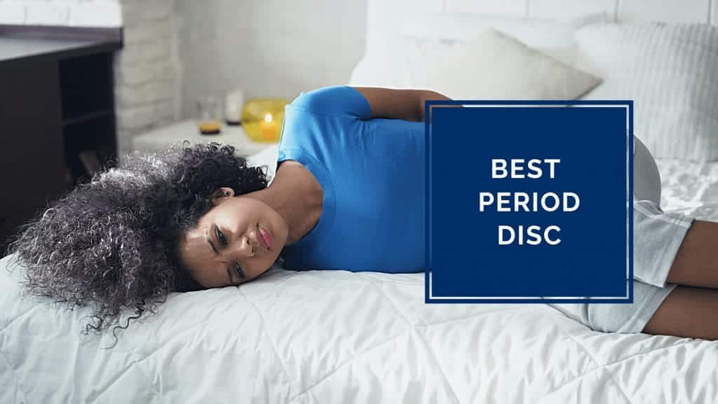 A woman lies on her bed feeling pms symptoms.