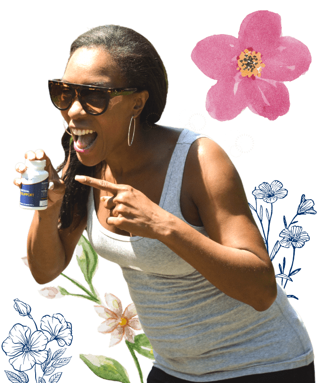 A woman smiles, pointing to her Jubilance for PMS with a flowered background.