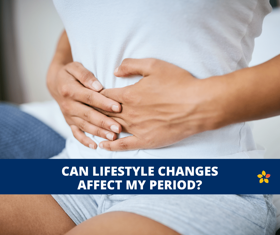 A woman clutches her pelvis from period pain as we question whether lifestyle changes can affect our periods.