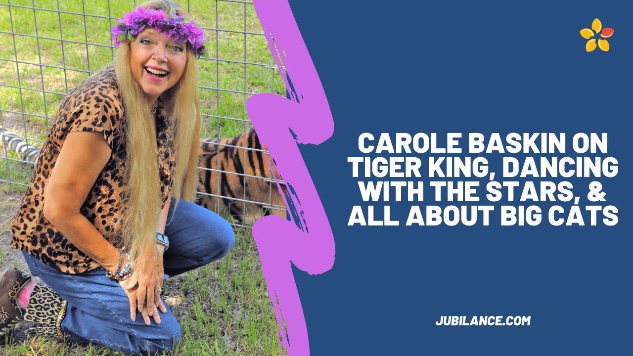 Carole Baskin smiles out at the camera with her iconic flower crown next to a caged Tiger.
