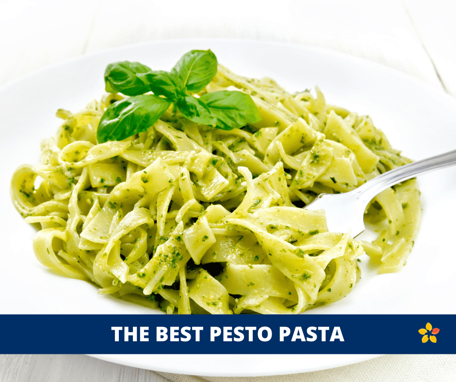 A big bowl of pesto pasta and basil on top.