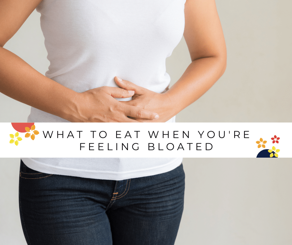 A woman holds her stomach feeling bloated, here are things you should eat when you're feeling bloated.