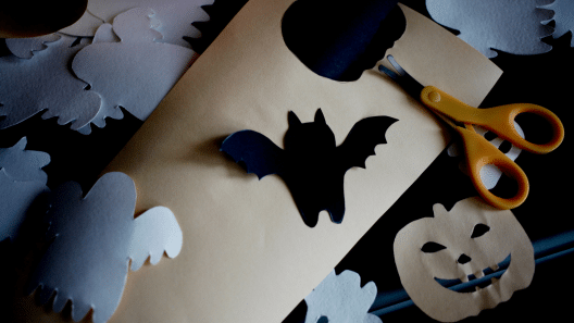 Bats, pumpkins, and ghosts are cut out of paper.